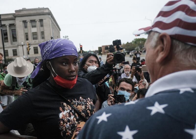 A demonstrator, left, and a supporter of U.S. President Donald Trump, right, engage in verbal arguments near Civic Center Park in Kenosha, Wisconsin, U.S., on Tuesday, Sept. 1, 2020. Donald Trump lauded police and National Guard members in Kenosha, Wisconsin, on Tuesday, where the shooting of a Black man by police last month has reignited national protests against racial inequality and street violence the president has sought to blame on Democrats. Photographer: Matthew Hatcher/Bloomberg