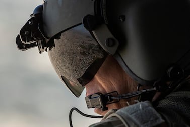 The Iraqi capital Baghdad reflected in the visor of a US Army helicopter crew member. All 'non-emergency' staff have been pulled from Iraq as uncertainty builds over the US's relationship with Iran. Reuters
