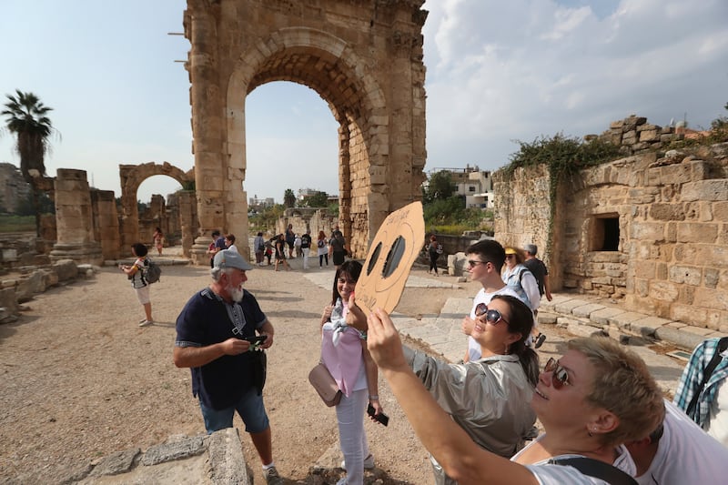 Tourists using a handmade protective viewing filter sheet to watch the partial solar eclipse, at the Phoenician ruins, in the southern port city of Tyre, Lebanon. AP