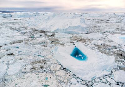 Turquoise water in a large melt hole on top of an iceberg in western Greenland. AFP