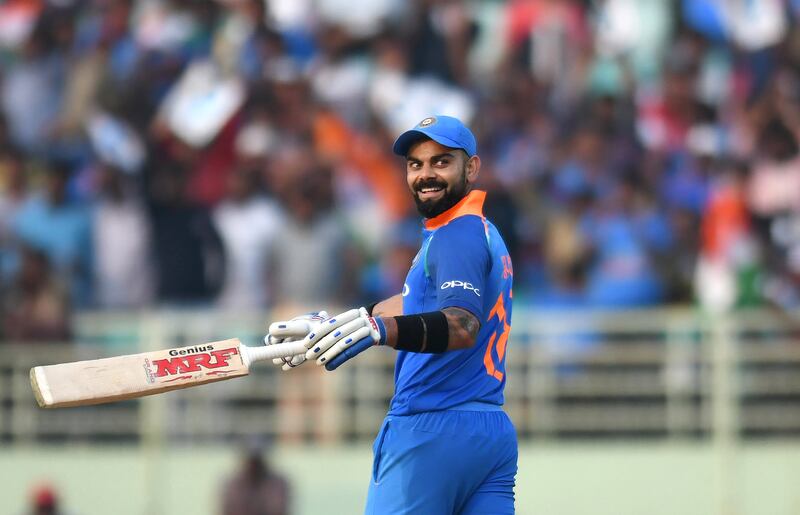 Indian cricket captain Virat Kohli smiles after completing to score 10,000 runs, surpassing the Indian cricket legend Sachin Tendulkar in the ODI format, during the second one day international (ODI) cricket match between India and West Indies at the Dr. Y.S. Rajasekhara Reddy ACA-VDCA Cricket Stadium in Visakhapatnam on October 24, 2018. (Photo by NOAH SEELAM / AFP) / ----IMAGE RESTRICTED TO EDITORIAL USE - STRICTLY NO COMMERCIAL USE----- / GETTYOUT