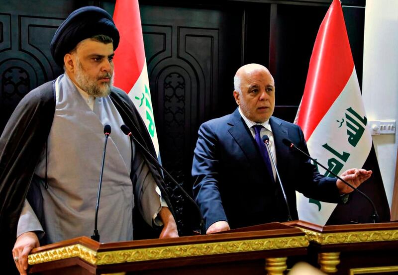 In this photo provided by the Iraqi government, Iraqi Prime Minister Haider al-Abadi, right, and Shiite cleric Muqtada al-Sadr hold a press conference in the heavily fortified Green Zone in Baghdad, Iraq, early Sunday, May 20, 2018. Shiite cleric Muqtada al-Sadr, whose coalition won the largest number of seats in Iraq's parliamentary elections, says the next government will be "inclusive." The May 12 vote did not produce a single bloc with a majority, raising the prospect of weeks or even months of negotiations to agree on a government. (Iraqi Government via AP)