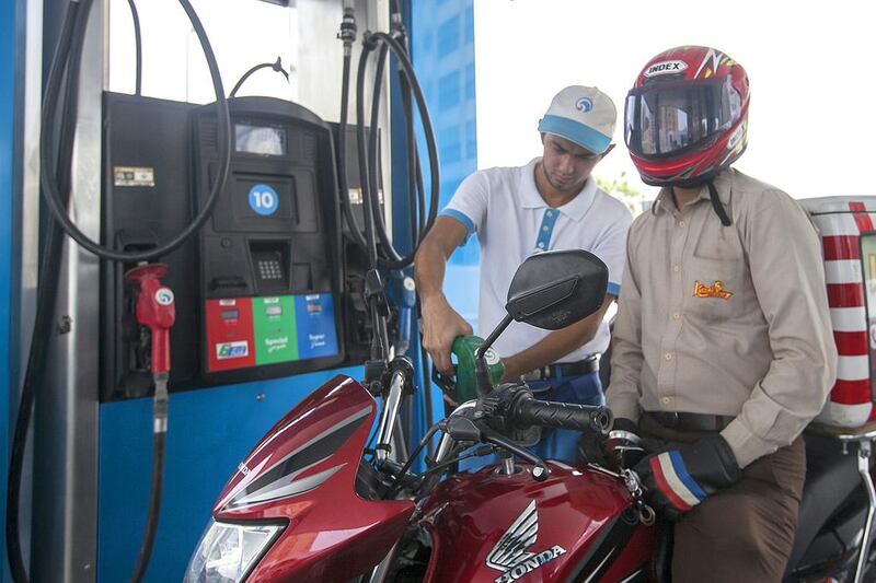 A motorcyclist fills up at an Adnoc station in Abu Dhabi. Mona Al Marzooqi / The National 