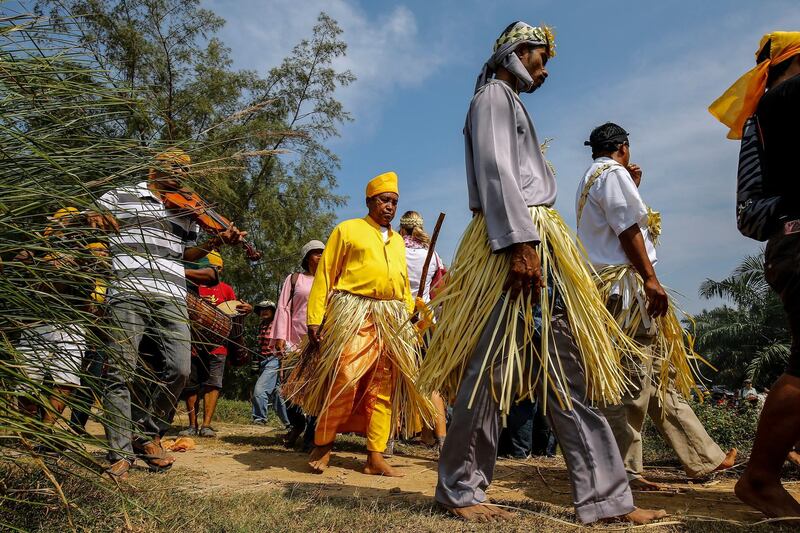 epa06546231 Members of Malaysia's Mahmeri tribe march along to the sea to pray for their ancestors during a thanksgiving ceremony in Pulau Carey, Kelang near Kuala Lumpur, Malaysia, 20 February 2018. The thanksgiving ceremony is to appease the sea spirits on the seabed of Malacca Straits during low tide. They marched from their village to the sea along with their shaman to perform ritual food offerings to seek blessing and protection of their seafaring ancestors.  EPA/AHMAD YUSNI