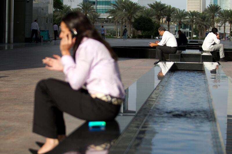 Dubai, Jan 16th, 2012 --  DIFC STOCK -  Business people on cellphones in DIFC. Photo by: Sarah Dea/ The National mobile phone cell