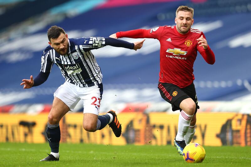 WEST BROMWICH, ENGLAND - FEBRUARY 14: Luke Shaw of Manchester United and Robert Snodgrass of West Bromwich Albion battle for possession during the Premier League match between West Bromwich Albion and Manchester United at The Hawthorns on February 14, 2021 in West Bromwich, England. Sporting stadiums around the UK remain under strict restrictions due to the Coronavirus Pandemic as Government social distancing laws prohibit fans inside venues resulting in games being played behind closed doors. (Photo by Michael Steele/Getty Images)