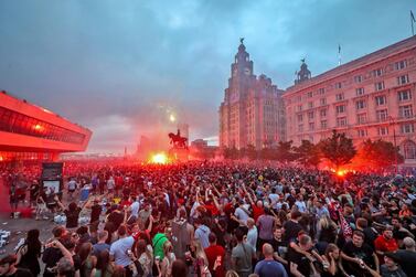 Liverpool fans let off flares outside the Liver Building in Liverpool, Friday June 26, 2020, as Liverpool soccer fans gather and celebrate for the team clinched the English Premier League title. (Peter Byrne/PA via AP)