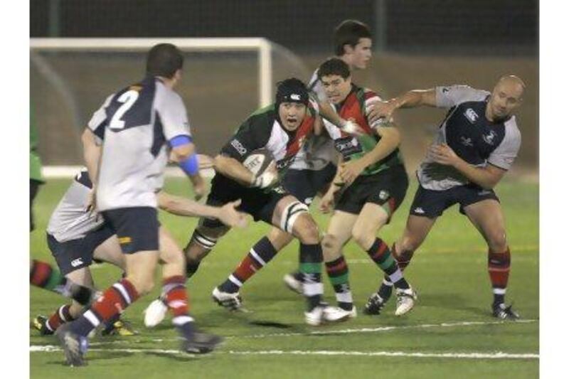 Jamie Clarke, centre, shown here running the ball for the Abu Dhabi Harlequins last season, wants to play for the UAE national team.