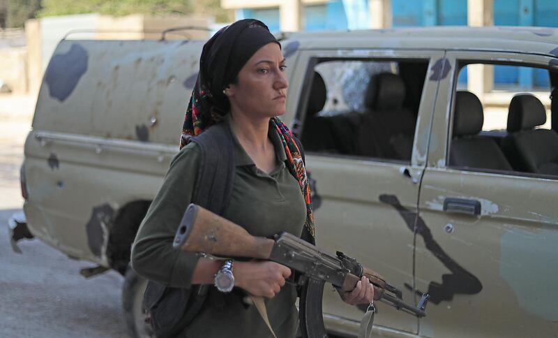 A member of the Asayish, Kurdish internal security police forces, walks by a government forces' pick-up truck. AFP