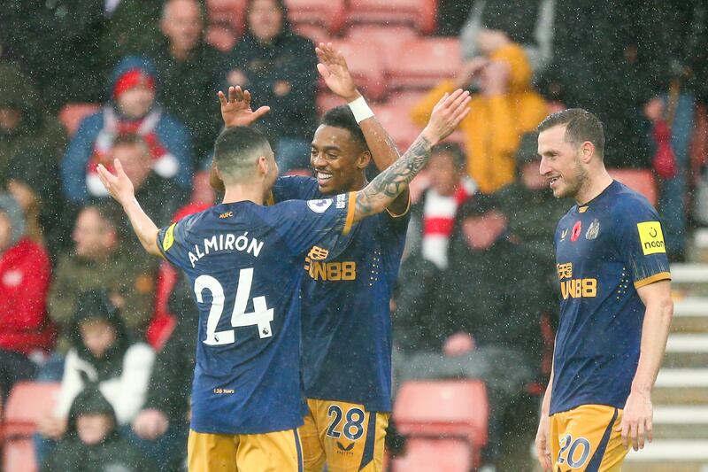 Joe Willock celebrates with Miguel Almiron after scoring Newcastle's third goal. Getty