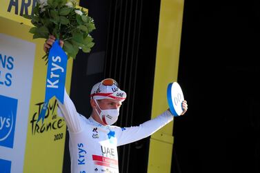 UAE Team Emirates rider Tadej Pogacar celebrates on the podium after retaining the white jersey in the Tour de France. Reuters