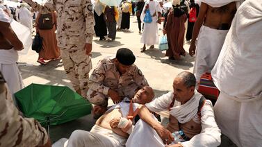 A man suffering from heat exhaustion is assisted by a member of the Saudi security forces in Mina. AFP