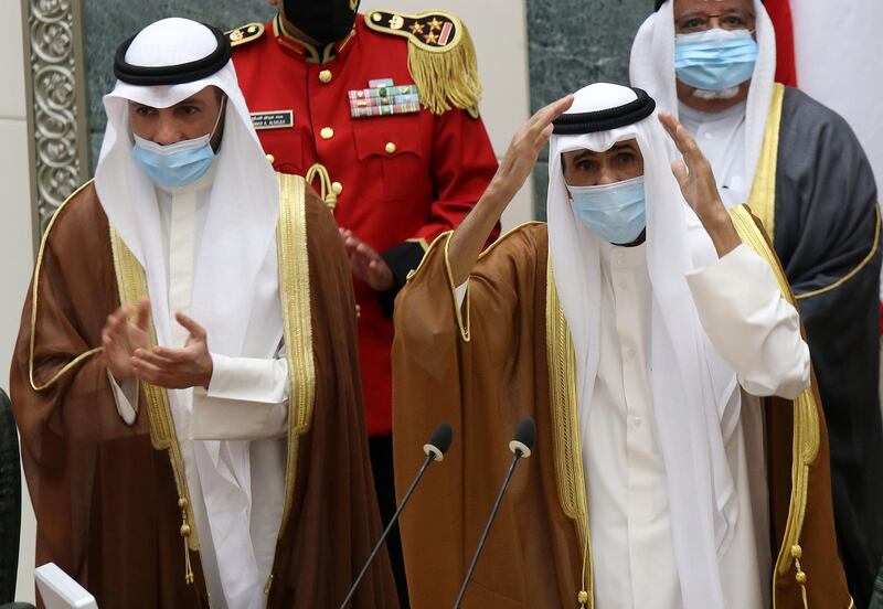 Sheikh Nawaf Al Sabah, left, salutes the crowd after being sworn in as Kuwait's new Emir at the National Assembly in Kuwait City. AFP