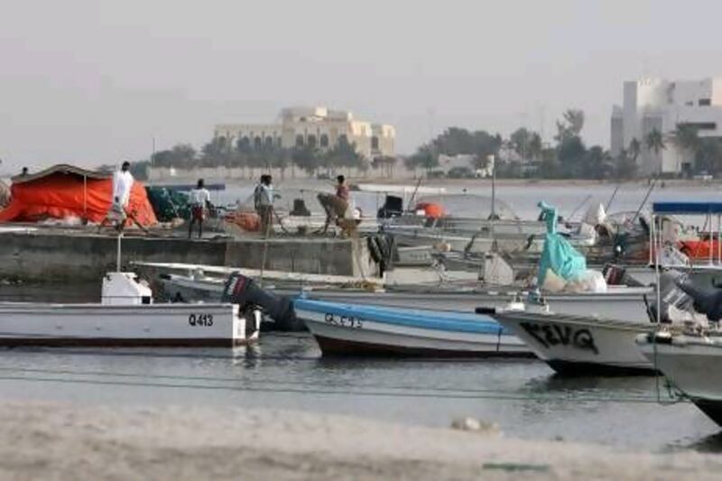 Fishing boats moored at the harbour overlooking the Old Town area of Umm Al Quwain.