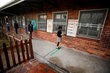 Learners observe social distancing markers as they queue at a school feeding scheme in in Cape Town, South Africa. Reuters
