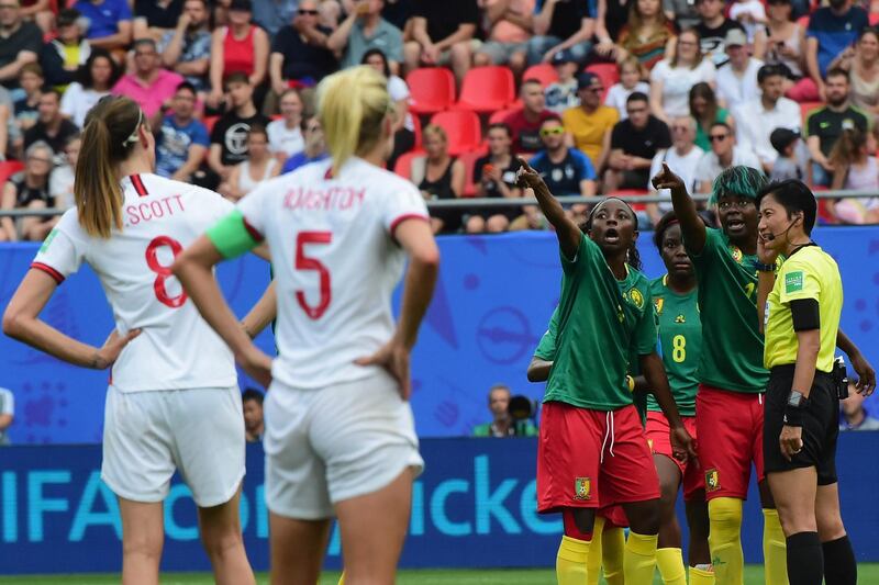 VALENCIENNES, FRANCE - JUNE 23:  Players of Cameroon speak with referee Qin Liang during the 2019 FIFA Women's World Cup France Round Of 16 match between England and Cameroon at Stade du Hainaut on June 23, 2019 in Valenciennes, France.  (Photo by Pier Marco Tacca/Getty Images)