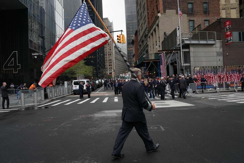 An airline pilot carries an American flag during observances at the Ground Zero memorial site in New York. AFP