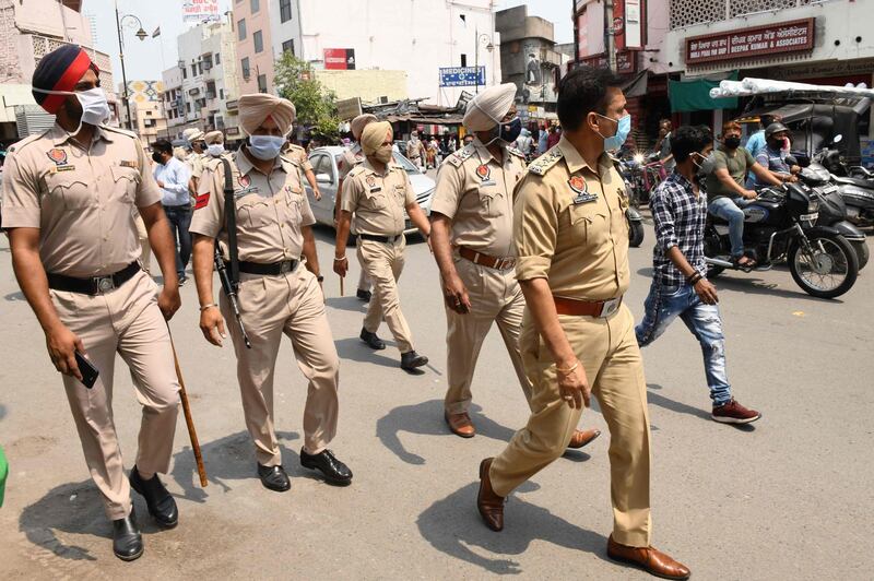 Police personnel patrol a market area during a lockdown imposed to curb the spread of the Covid-19 Coronavirus, in Amritsar on May 10, 2021. / AFP / NARINDER NANU
