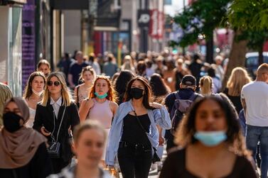 Pedestrians, some wearing face coverings owing to Covid-19, walk past shops on Oxford Street in central London. AFP