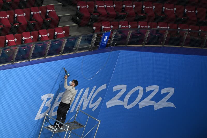 A worker prepares the apron of the arena during practice at the Wukesong Sports Centre. Getty 