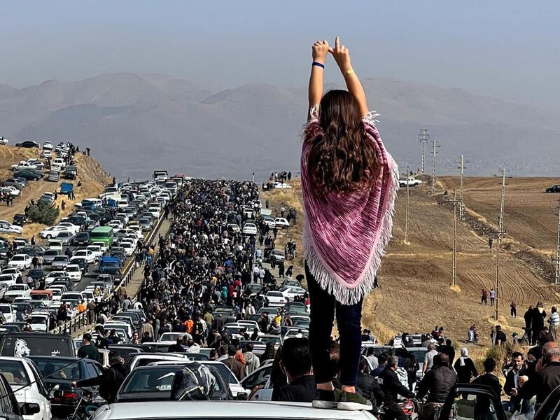 An woman defies Iranian law that demands she must cover her head as thousands make their way towards Aichi cemetery in Saqez, the burial place of Mahsa Amini, who died while in police custody for not obeying that law. AFP