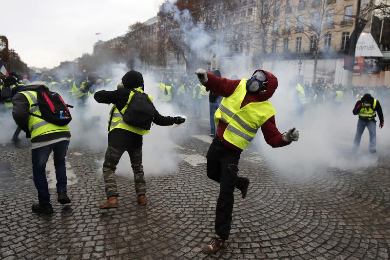 epa07216418 Yellow Vests protesters hurl back tear gas to  French riot police during a demonstration in Paris, France, 17 November 2018. Police in Paris is preparing for another weekend of protests of the so-called 'gilets jaunes' (yellow vests) protest movement. Recent demonstrations of the movement, which reportedly has no political affiliation, had turned violent and caused authorities to close some landmark sites in Paris this weekend.  EPA/IAN LANGSDON