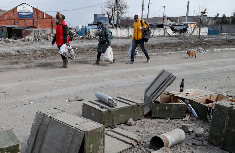 Mariupol residents pass shells and discarded munitions cases as they try to flee the besieged port city on the north coast of the Sea of Azov at the mouth of the Kalmius river. Reuters