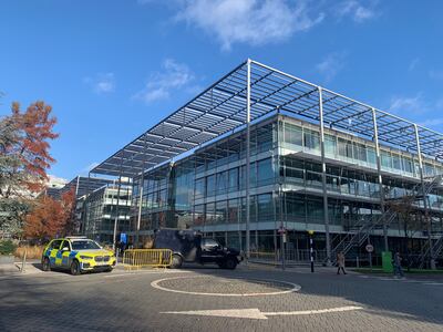 An armoured police vehicle and a police response car parked outside Iran International's former newsroom in west London. The National