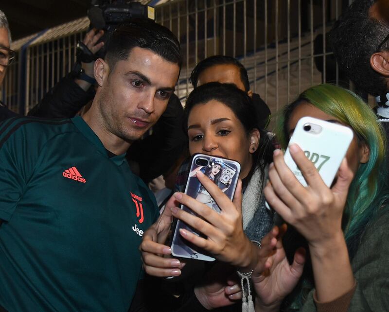 Cristiano Ronaldo signs autographs and poses for selfies before the training session in Riyadh. Getty