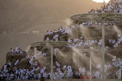 Water is sprayed on Muslim pilgrims as they pray on the rocky hill known as the Mountain of Mercy, on the Plain of Arafat, during the annual Hajj pilgrimage, near Makkah. AP
