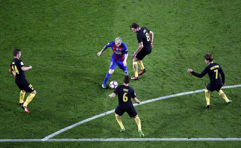 FC Barcelona’s Lionel Messi, centre, in action against Atletico Madrid. Alberto Estevez / EPA