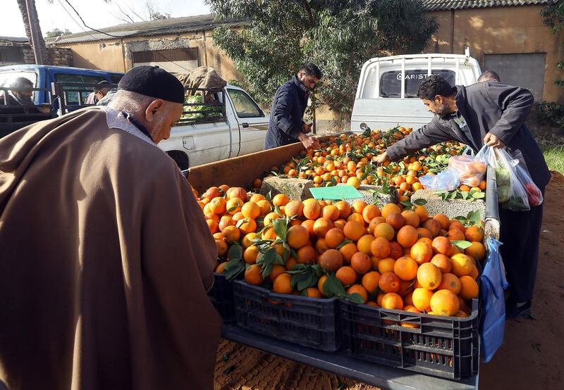 Libyans buy oranges at a farmers market, which takes place every Monday and Thursday offering fresh produce, in the capital Tripol. AFP