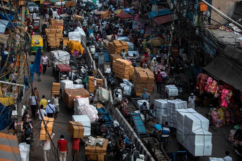 People and vehicles move along a busy street in the old quarters of New Delhi on July 27, 2020. / AFP / Xavier GALIANA
