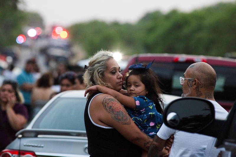 Rose Perez holds on to her mother, Scarlet Chavez, on the edges of the grim scene. Reuters
