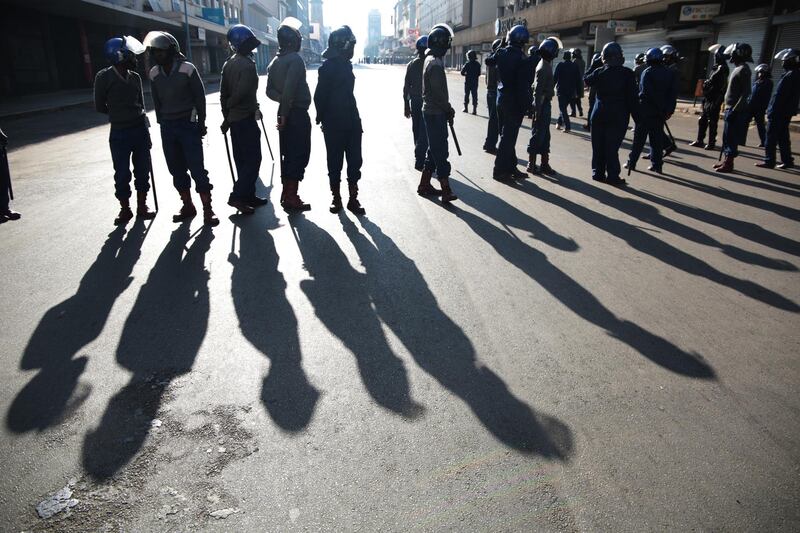 Members of ZRP block the road to contain the planned peace march. EPA