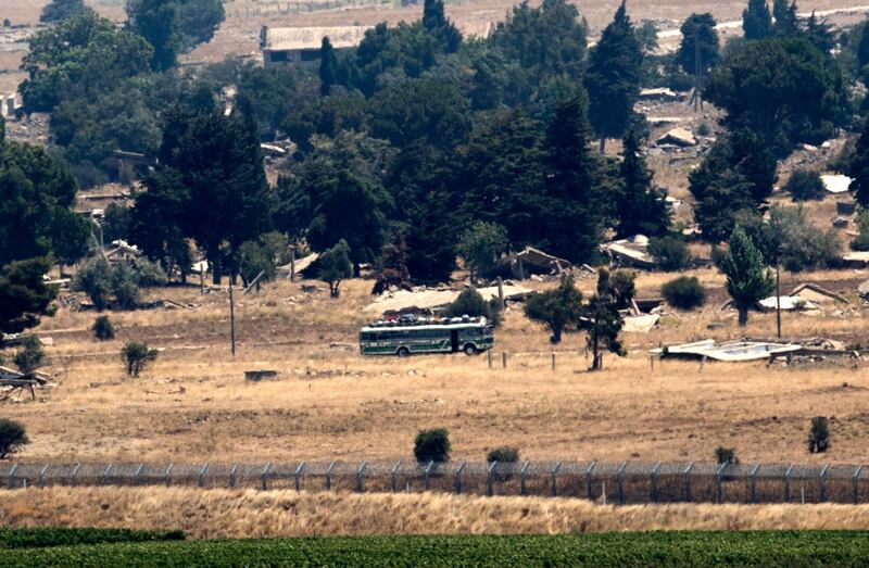 epa06903966 A general view of the busses carrying rebels leaving to the northern Syrian city of Idlib from the city of Quneitra by the Syrian-Israeli borders in the Golan Heights, as seen from the Israeli side of the border, 22 July 2018. The Syrian army backed by Russian air strikes launched an offensive on the rebels-held southwestern provience of Quneitra during the same month. Rebels and the Syrian army reached an agreement that allows rebels and their family to leave to the rebels-control northern city of Idlib. According to reports, Israel Defense Forces (IDF) evacuated some 800 of the Syrian Civil Defense (Also known as the White Helmets) and their families from Quneitra to Jordan at the request of the United States and several European countries, the reports also added that the IDF is not intervening in the ongoing conflict in Syria.  EPA/ATEF SAFADI