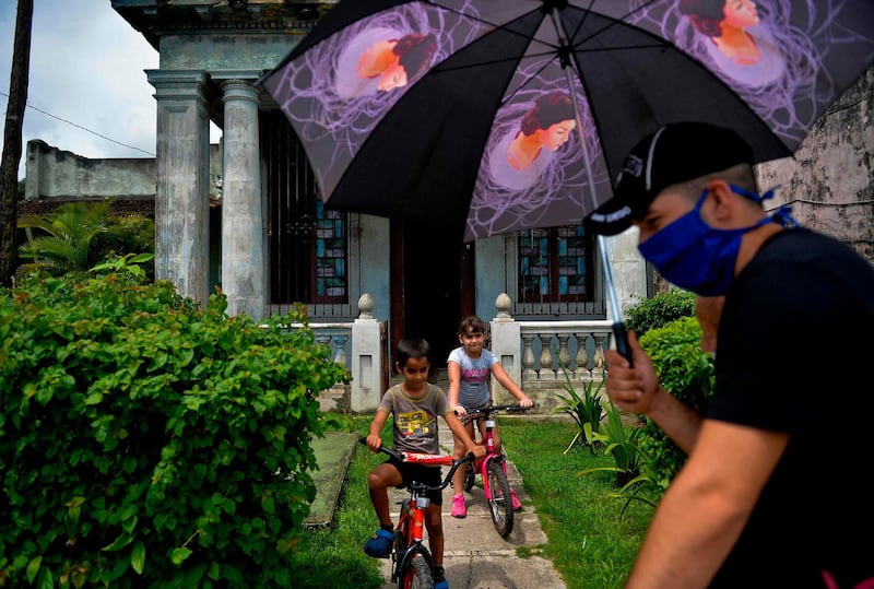 Children ride their bicycles, as the first phase to ease the quarantine imposed to prevent the spread of the new coronavirus starts, in San Jose de las Lajas, Mayabeque province, Cuba. AFP