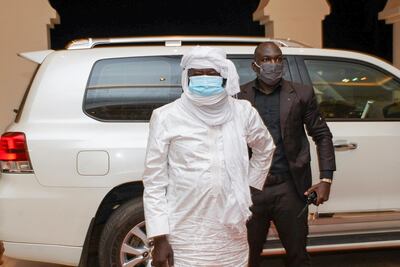 In this photo provided by the Mali Presidency, three-time Malian presidential candidate and ex-hostage Soumaila Cisse, center, arrives at the presidential palace after being released and flown to the capital Bamako, Mali, late Thursday, Oct. 8, 2020. A prominent Malian politician and three European hostages freed by Islamic extremists in northern Mali this week landed in the country's capital late Thursday where they held emotional reunions with family members and were greeted by government officials. (Mali Presidency via AP)
