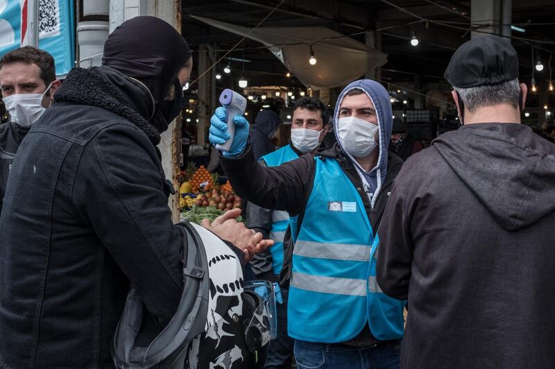 Besiktas municipality police and employees distribute masks, check ID's and take the temperature of people arriving at the entrance of the Besiktas market in Istanbul, Turkey. Getty Images