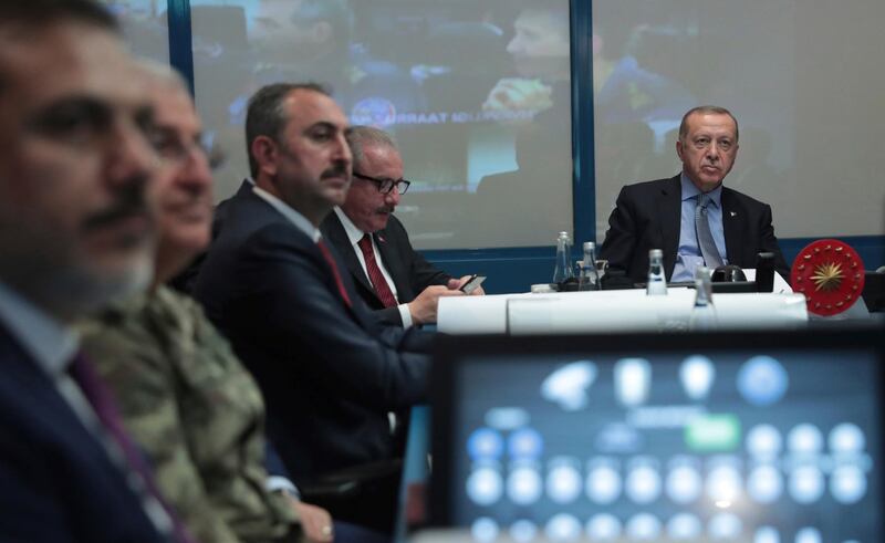 Turkey's President Recep Tayyip Erdogan, right, with military and Intelligence chiefs, ministers and his ruling party members in an operations room at the presidential palace, in Ankara, Turkey, on Wednesday, October 9, 2019.  Turkish Presidency Press Service via AP