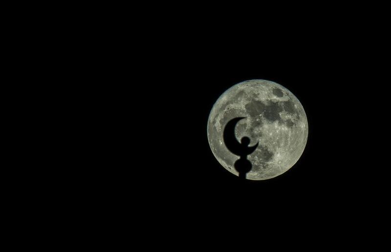 The supermoon rises over a mosque’s minaret in Kuwait city, Kuwait.  Raed Qutena / EPA