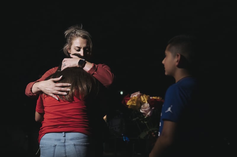 A woman embraces a child outside Willie de Leon Civic Centre, in Uvalde, where pupils were taken after the school shooting. Bloomberg