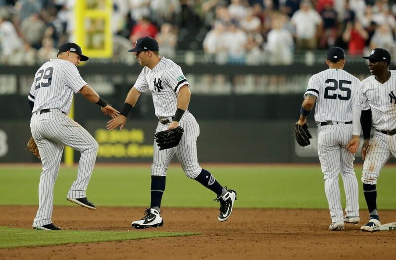 From left, New York Yankees' Gio Urshela, DJ LeMahieu, Gleyber Torres and Didi Gregorius celebrate after defeating the Boston Red Sox in a baseball game, in London. Major League Baseball made its European debut game Saturday at London Stadium.  AP