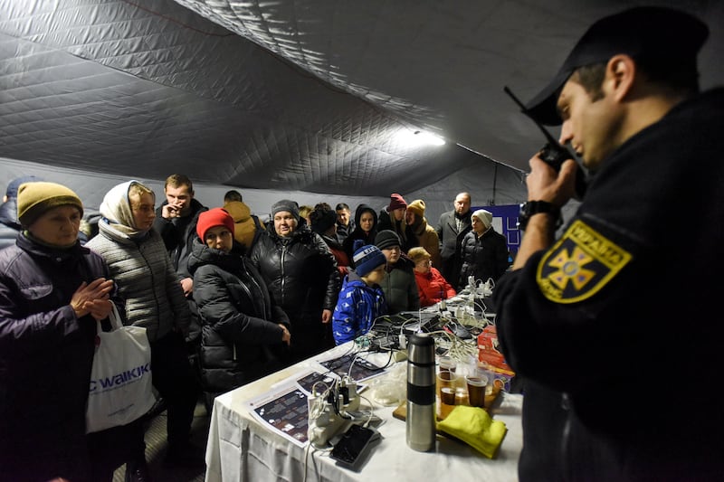 People charge their devices using a power generator in Kyiv. EPA