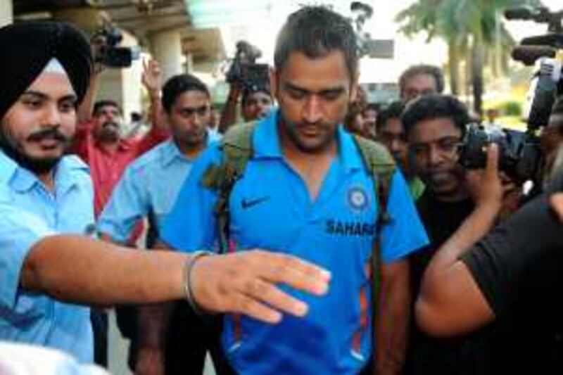Indian cricketer Mahendra Singh Dhoni is escorted to the team bus in Mumbai on September 18, 2009.  Dhoni's India left for South Africa keen to maintain their consistency to fulfill their fans' expectations at the Champions Trophy from Sept 22-October 5. India disappointed in the tournament's last edition at home in 2006 when they failed to qualify for the semi-finals, but have given their fans plenty to cheer about with their recent successes.   AFP PHOTO/Indranil MUKHERJEE