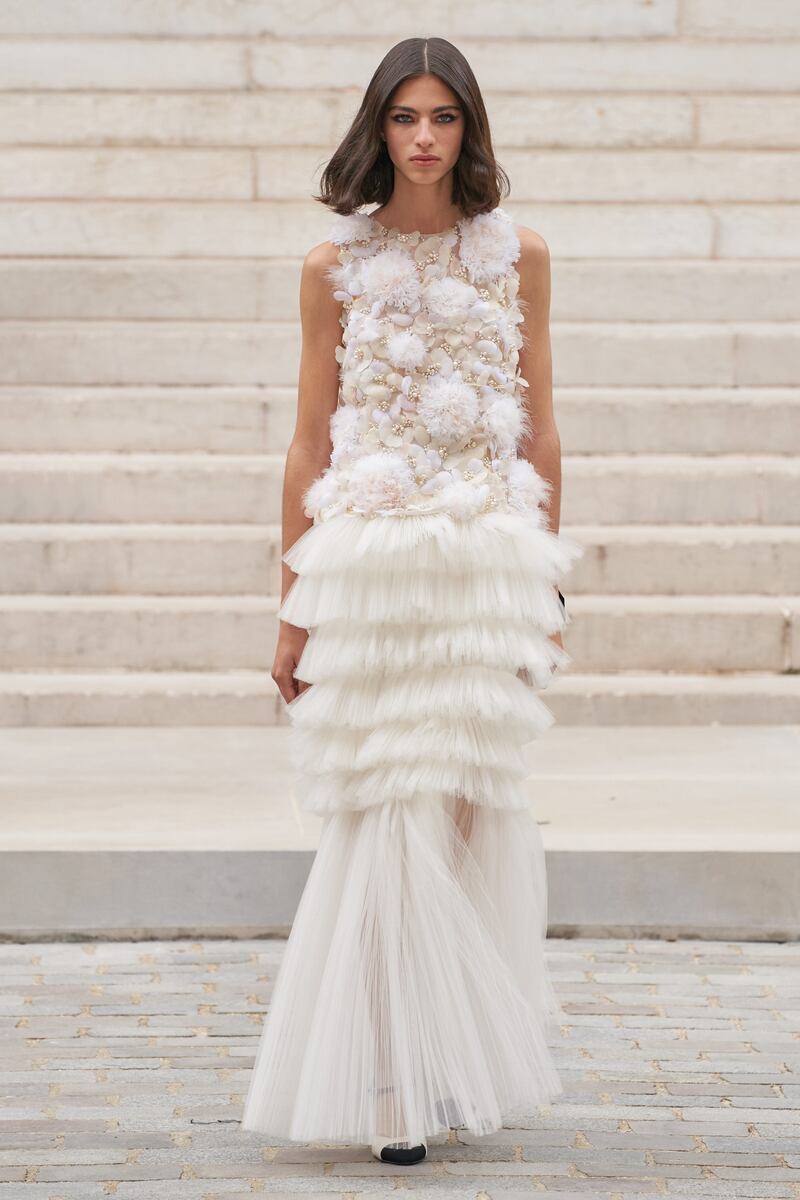 At Chanel, a white bridal gown was made with fragile tiers and hand-applied feathers for haute couture autumn / winter 2021.