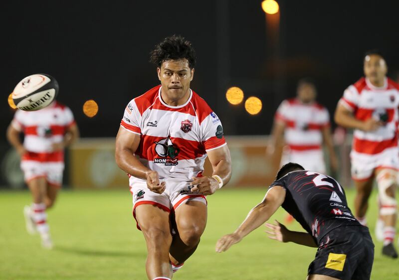 Dubai Tigers' Dueane Aholelei releases a pass before getting tackled in the game against the Dubai Exiles.