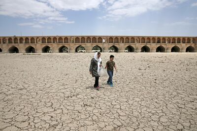 A woman and boy walk on the dried up riverbed of the Zayandeh Roud river in Isfahan, Iran. AP Photo