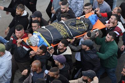 Palestinians carry one of 10 people killed in the Jenin raid during the funeral procession for the victims. AFP