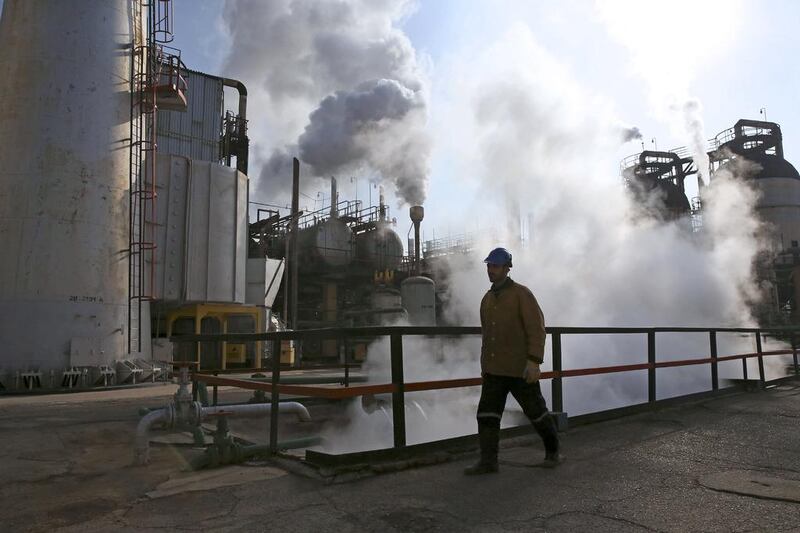 An Iranian oil worker walks in Tehran's oil refinery south of the capital Tehran, Iran, Monday, Dec. 22, 2014. (AP Photo/Vahid Salemi)